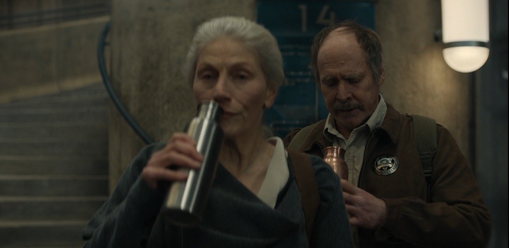 Mayor Ruth Jahns and Deputy Marnes drinking water on their way down the silo stairs in Silo Season 1 Episode 3